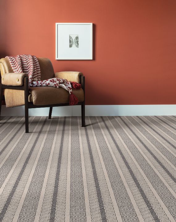 Orange painted walls with striped carpet. 